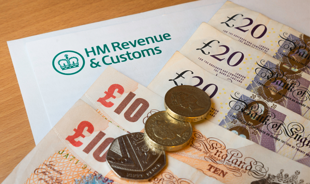 A pile of money and coins on top of a hm revenue and customs form