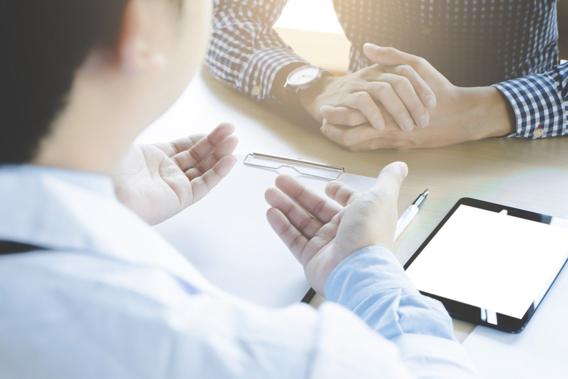A doctor is talking to a patient while sitting at a table.