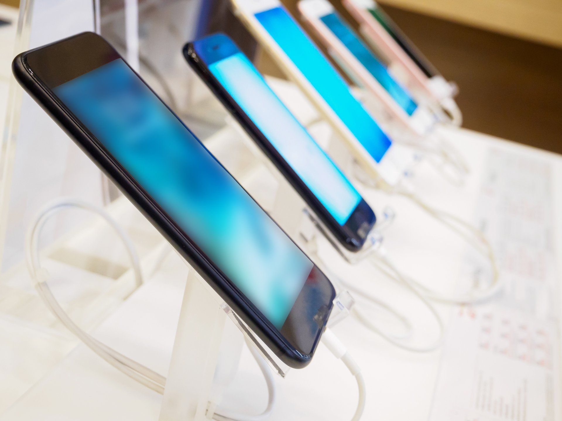 A row of cell phones on display in a store