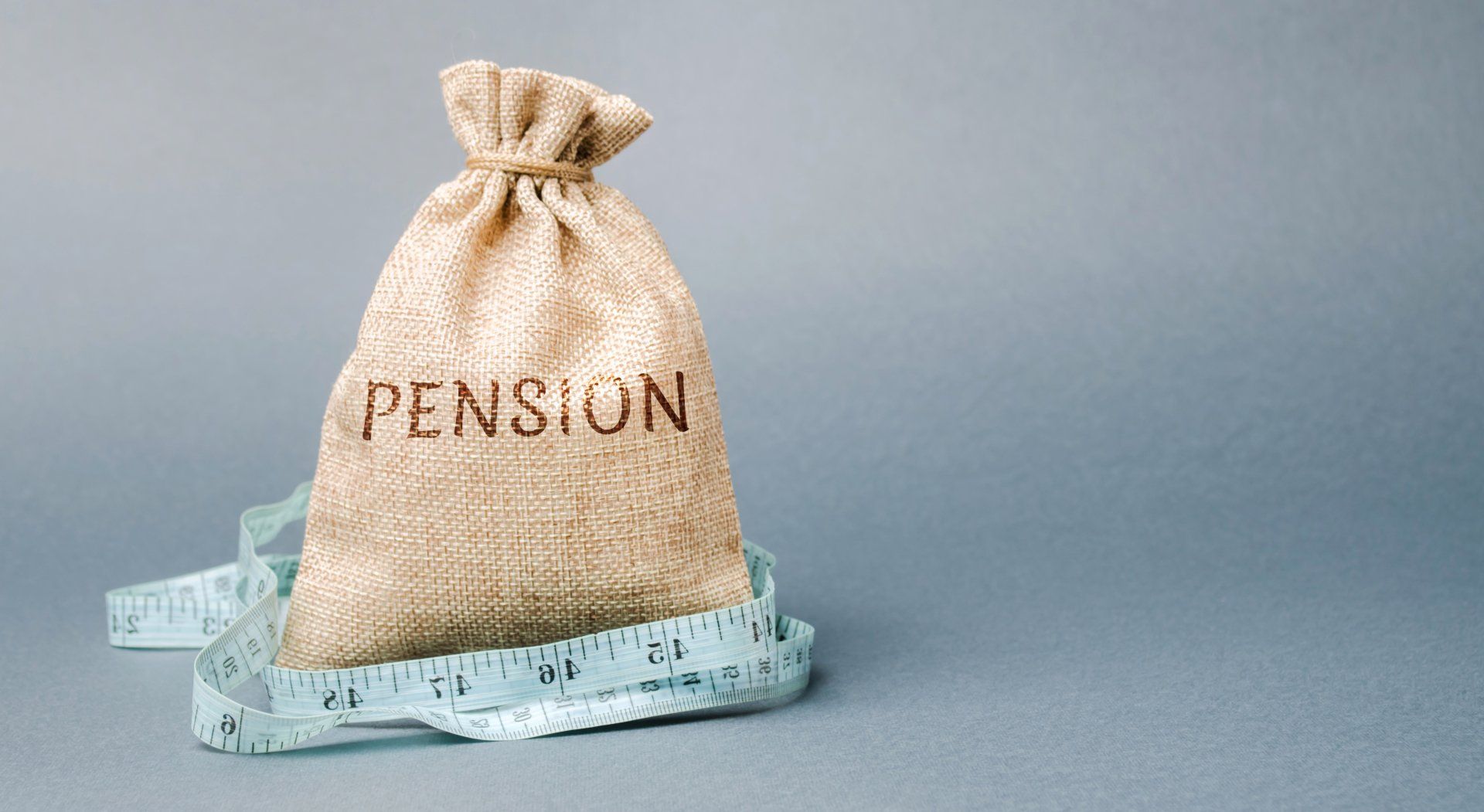 A bag with the word pension written on it is tied to a measuring tape.