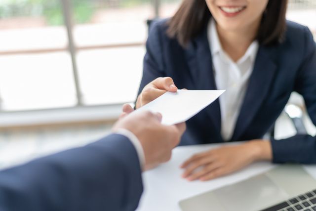 A man is handing a piece of paper to a woman.